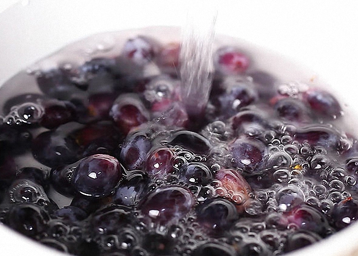 В мятый виноград налить воды и оставить в тепле