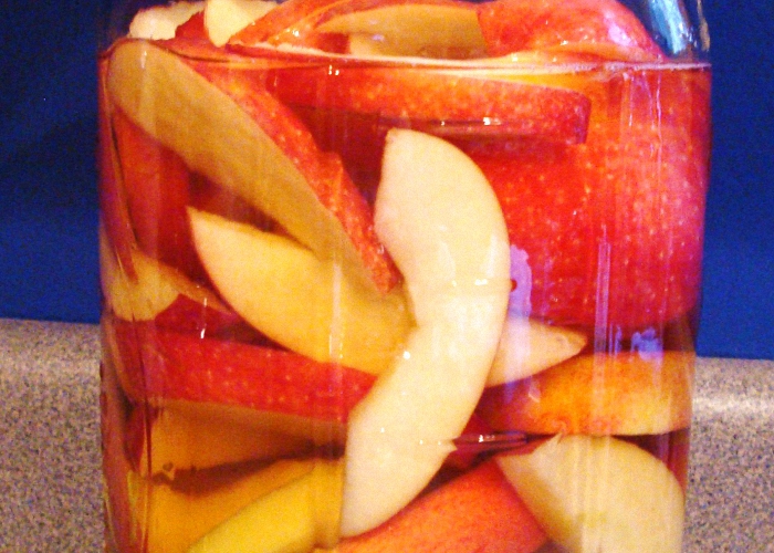 Наполнить яблоками банки и залить спиртом