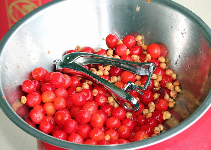 Спелые вишни переложить в удобную посуду и вынуть косточки