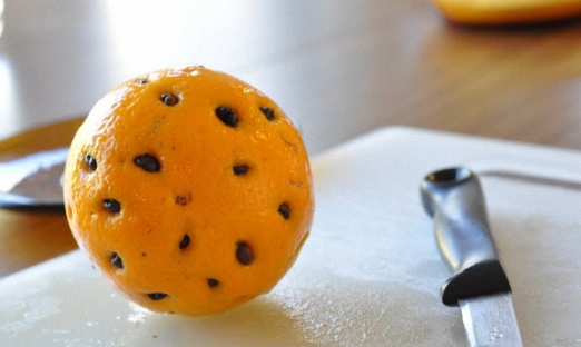 Апельсин прокалываем тонкой спицей и вставляем 44 кофейных зернышка