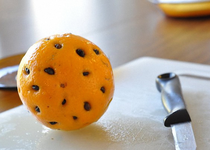 Сделать надрезы по окружности апельсина и вставить кофейные зерна